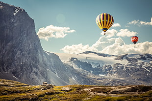 hot air balloon on flight over mountain alps