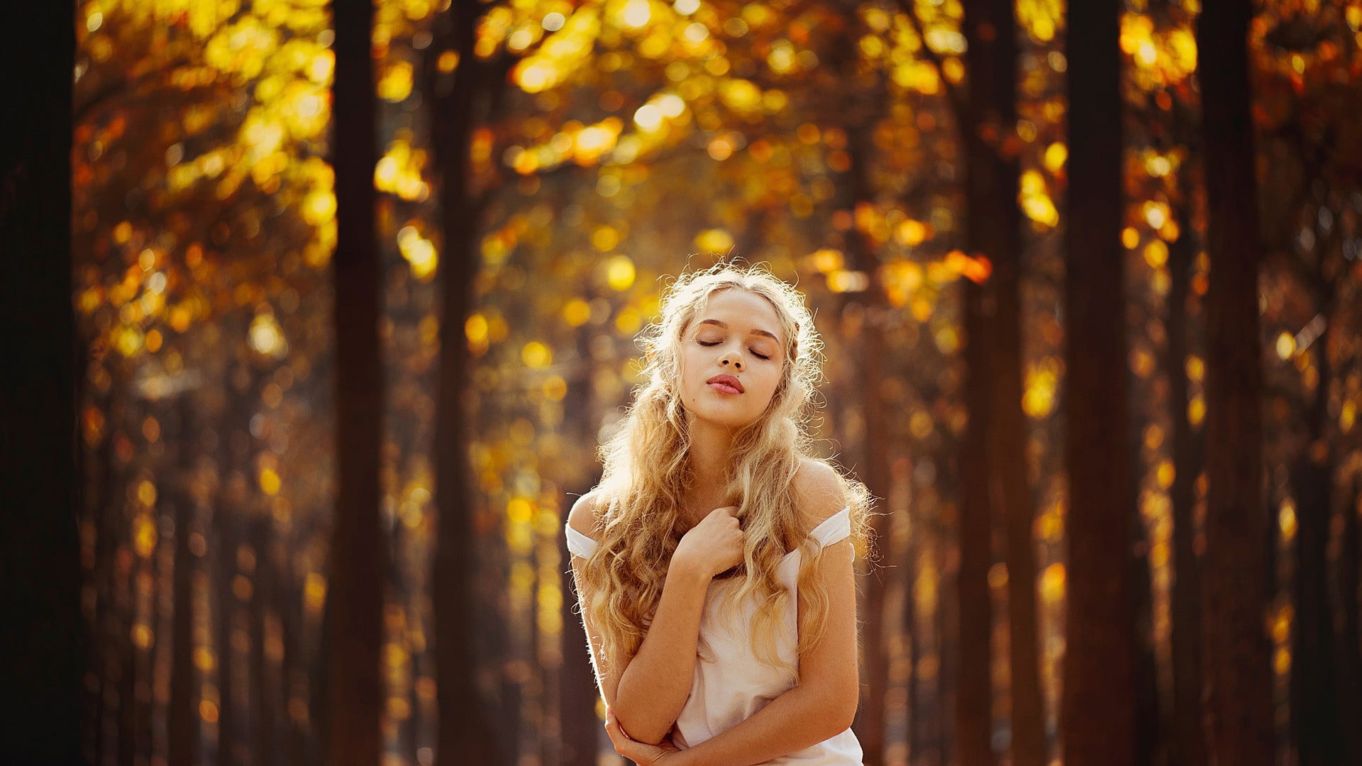 selective focus photo of woman closing her eyes wearing white off-shoulder top