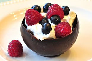 strawberry with raspberry and cream on bowl