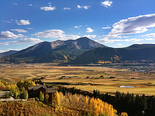 landscape photography of hill under white clouds and blue sky, crested butte, usa