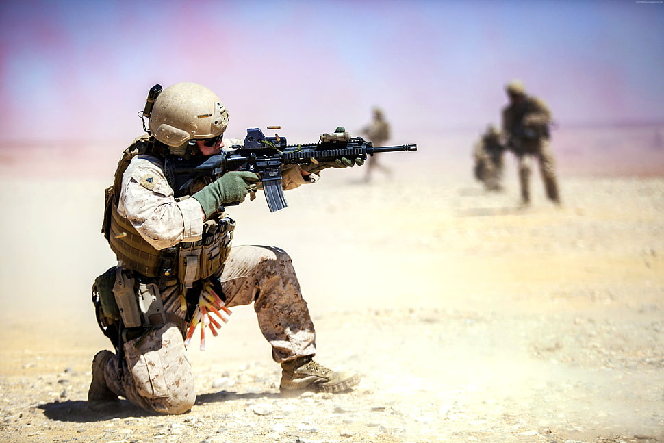 Soldier holding black assault rifle crouching HD wallpaper