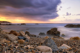 gray rocks beside body of water during sunset HD wallpaper