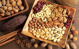 nuts on square brown wooden plate beside star anise