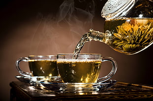 tea in clear glass teapot poured on clear glass tea cup with saucer HD wallpaper