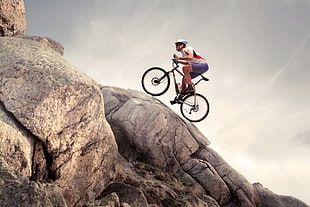 man riding bike on rock