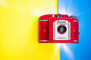 red and gray Beacon SLR camera on yellow and blue surface