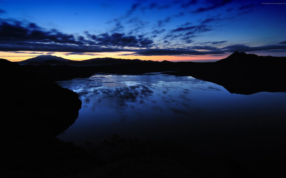 silhouette of mountain near lake during nighttime HD wallpaper