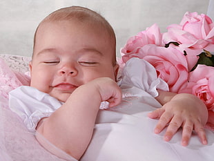 photo of baby wearing white top while closing her eyes HD wallpaper