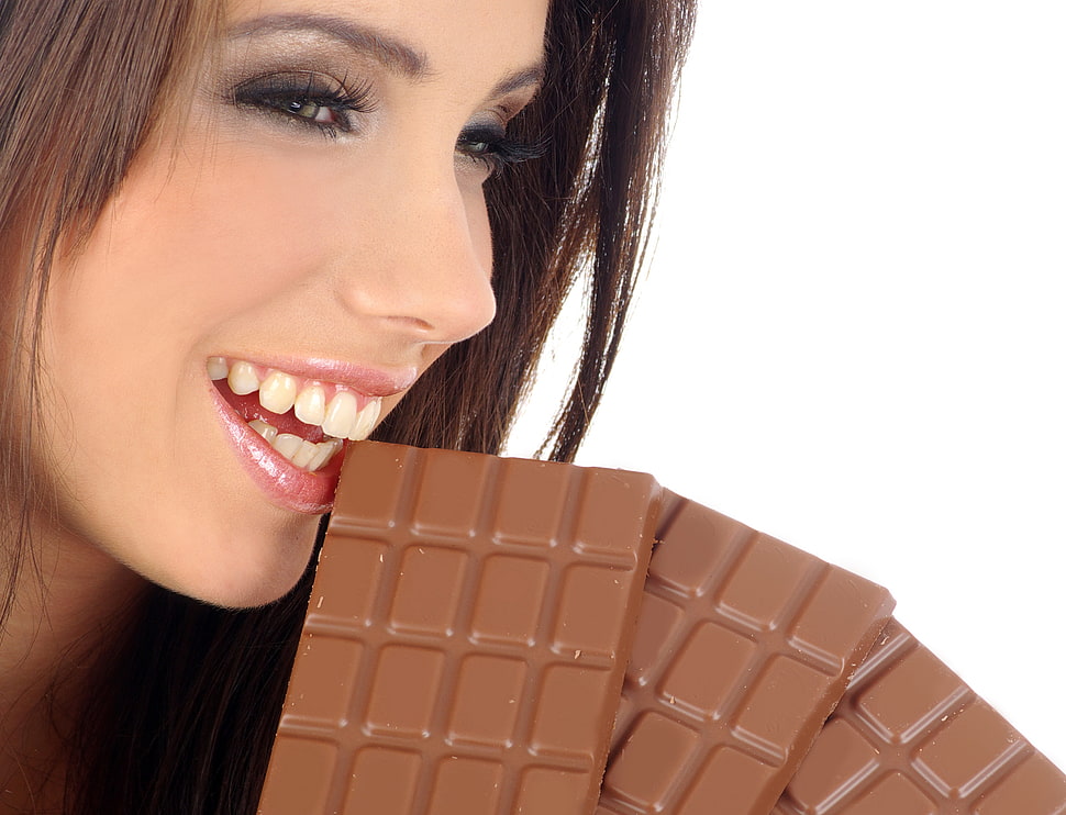 woman biting a chocolate bar photo HD wallpaper