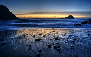 silhouette of mountain near seashore during sunrise HD wallpaper