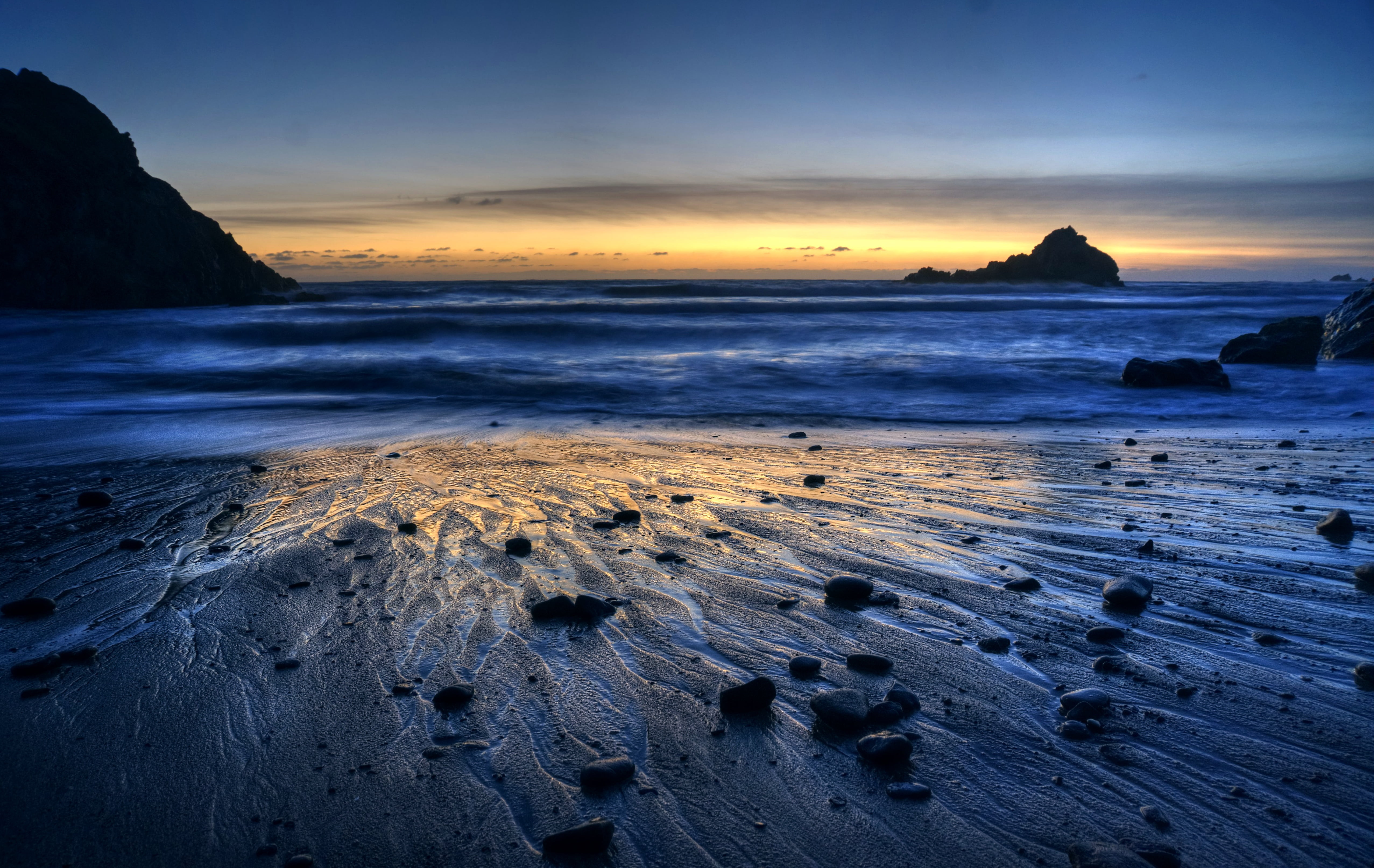 silhouette of mountain near seashore during sunrise