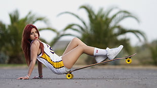 woman sitting on longboard wearing jersey shirt