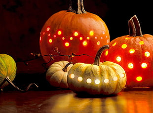 four orange and yellow pumpkins with yellow lights