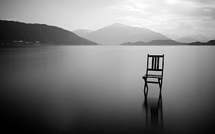 silhouette chair on top of lake
