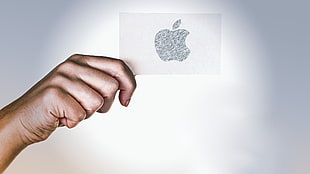 person holding Apple printed logo
