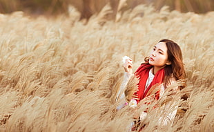brown haired woman wearing pink dress with red scarf on wheat fields
