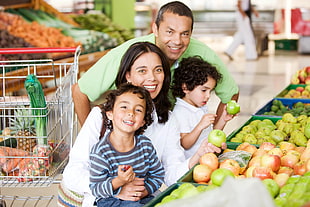 family taking photo near box of fruits and stainless steel shopping cart
