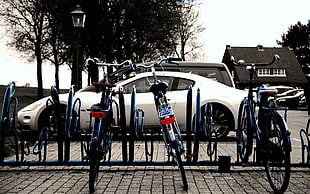 three bikes on blue bike parking rack HD wallpaper