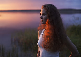 woman standing near grass and body of water