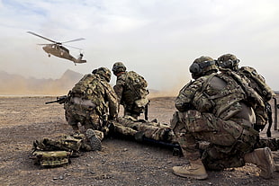 Military Soldiers carrying a body towards a helicopter