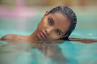 closeup photo of woman on water looking on camera