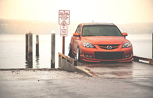 red Mazda 3 parked near body of water HD wallpaper
