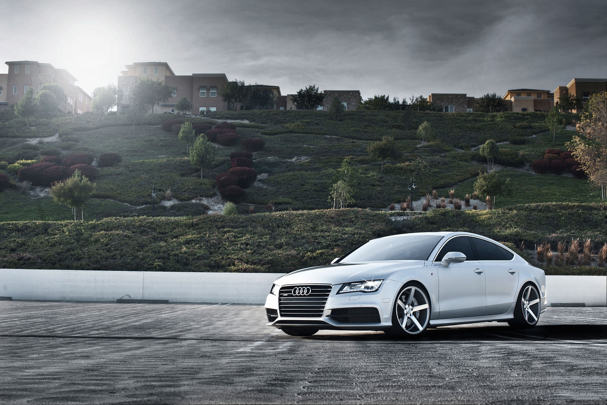 photography of silver Audi A4 near brown establishments during daytime