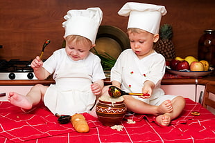 2 babies wearing chef's clothing