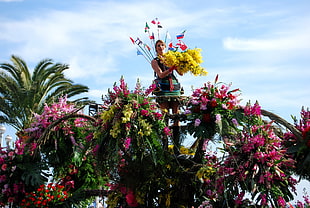 woman carrying yellow petaled flowers with flaglets