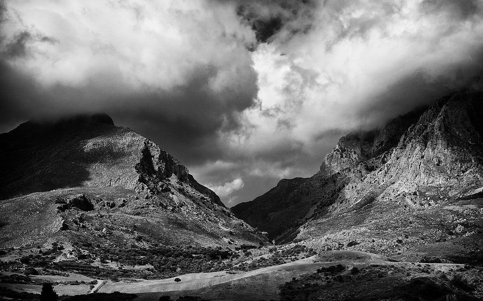 grayscale photo of mountain range under cloudy sky HD wallpaper