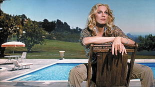 woman sitting on adirondack chair against the swimming pool