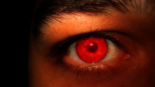photo of human eye with red contact lens