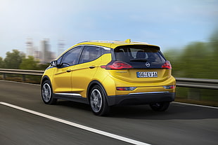 yellow Opel 5-door hatchback on concrete road during daytime HD wallpaper