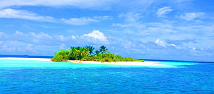 photo of islet surrounded with blue body of water during daytime