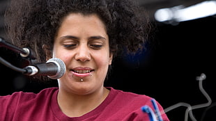 person wearing maroon crew-neck t-shirt near microphone