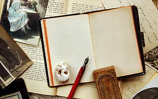 white notebook beside ink pen