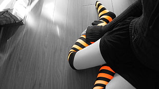 person wearing orange and black striped socks