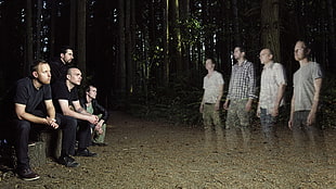 four man sitting on brown wooden logs