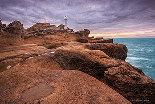 white lighthouse on top of brown mountain during day time, castlepoint HD wallpaper
