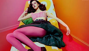 woman wearing pink crop-top lying on sofa