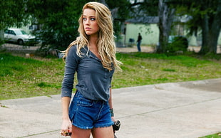 woman wearing gray elbow-sleeved shirt and blue denim shorts