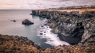 a view of cliff under cloudy sky, hellnar, iceland