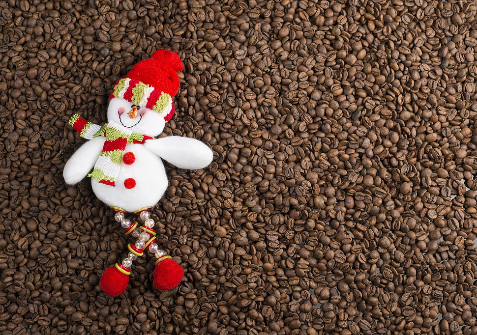 snowman with red and green beanie and scarf on bunch of brown coffee beans HD wallpaper