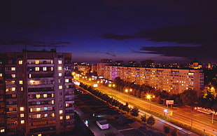 brown apartment building beside the road during night