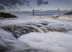lighthouse on body of water during daytime HD wallpaper