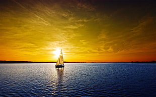 photography of sailing boat on body of water during golden hour