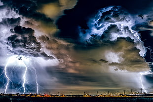 clouds and lightning striking cityscape photo HD wallpaper