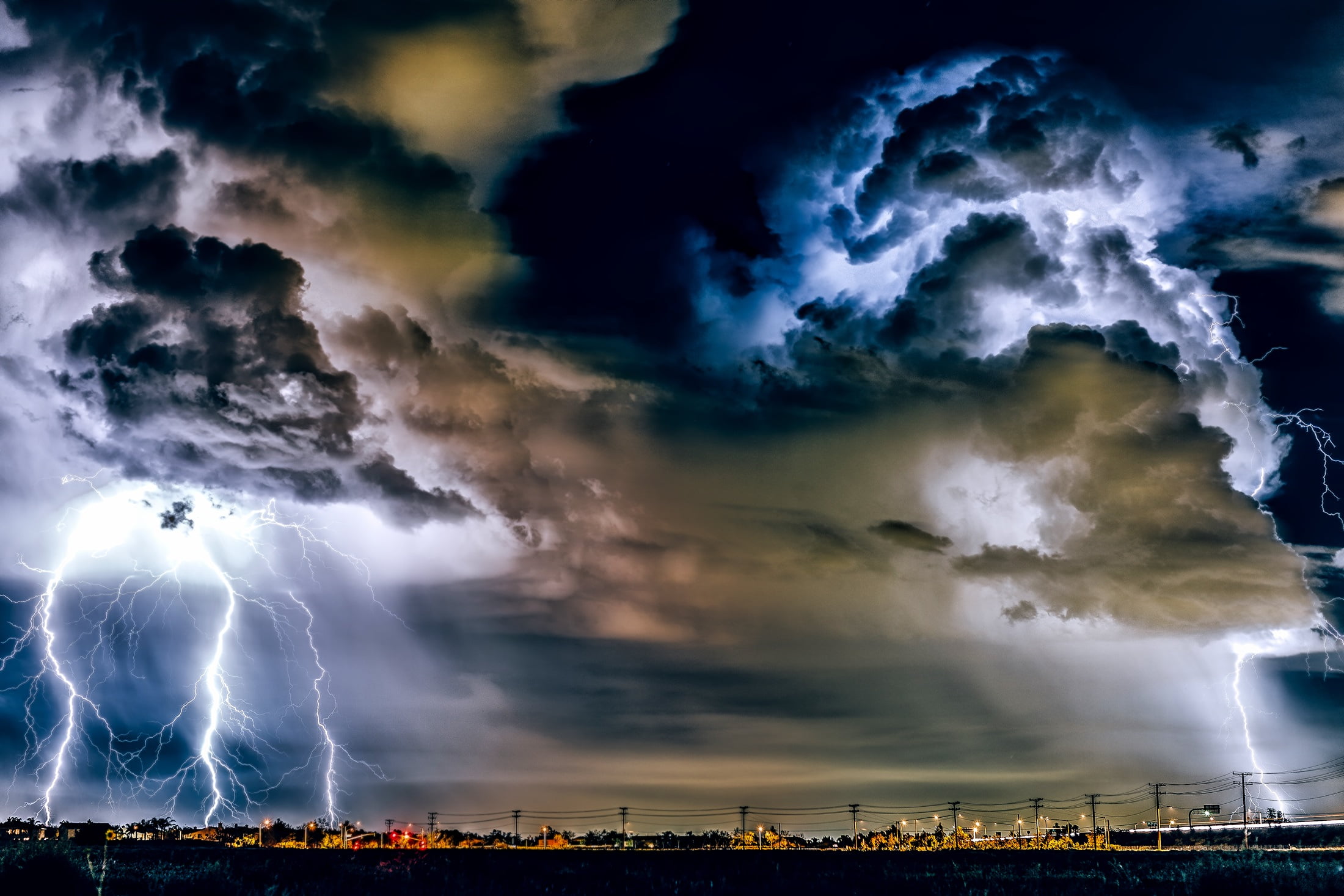 clouds and lightning striking cityscape photo