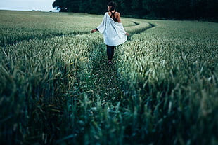 photo of woman walking on grass path