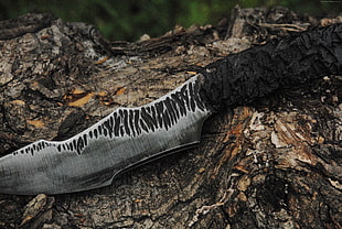 black handle hunting knife on brown wood